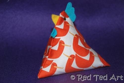 A cheerful fabric pyramid with a chicken head on the top.